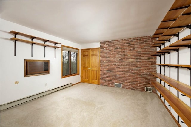 unfurnished room with brick wall, a wall mounted air conditioner, visible vents, and a baseboard heating unit