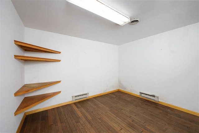 unfurnished room with hardwood / wood-style flooring, baseboards, and baseboard heating