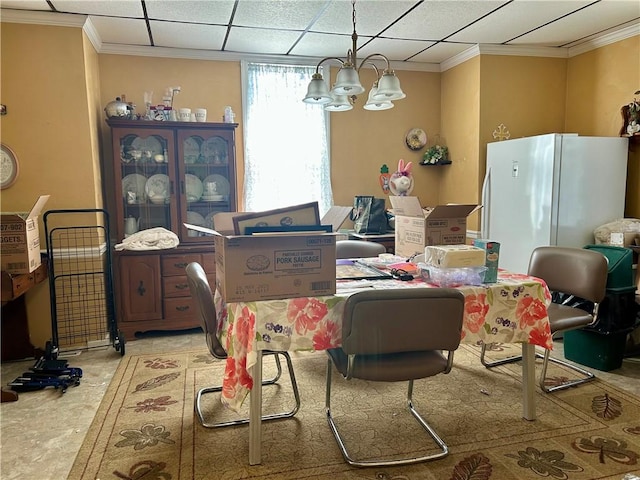 dining area featuring ornamental molding, a notable chandelier, and a paneled ceiling
