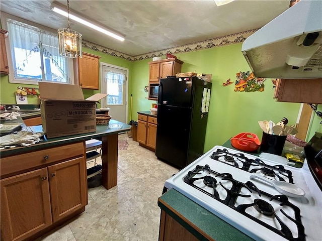 kitchen with built in microwave, freestanding refrigerator, dark countertops, exhaust hood, and gas stove