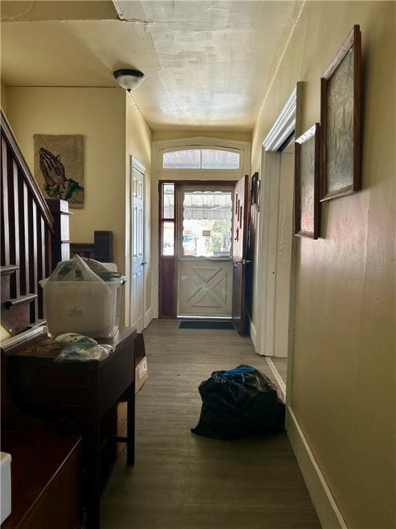 entryway featuring baseboards, stairway, and wood finished floors