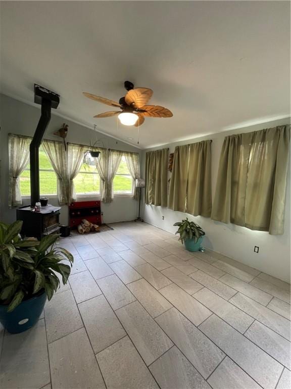 empty room with vaulted ceiling, ceiling fan, and light tile patterned flooring