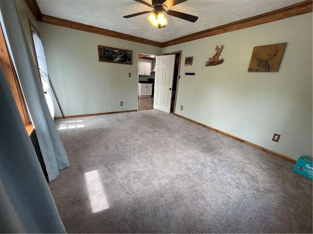 unfurnished room featuring baseboards, crown molding, ceiling fan, and carpet