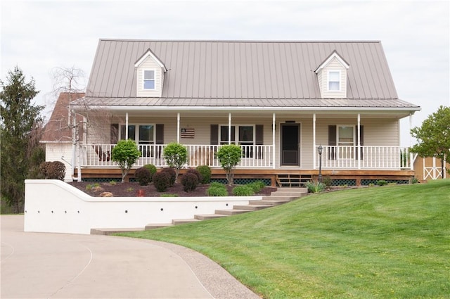 view of front facade with a porch, metal roof, and a front lawn
