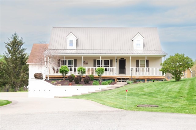 view of front of house featuring covered porch, metal roof, and a front yard