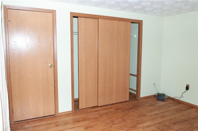 unfurnished bedroom featuring light wood-style floors and baseboards