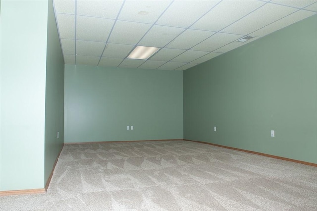 spare room featuring light carpet, baseboards, and a paneled ceiling