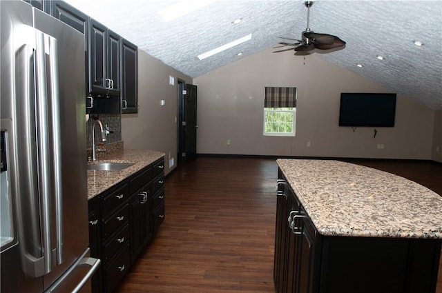 kitchen featuring a ceiling fan, stainless steel fridge with ice dispenser, open floor plan, and a sink