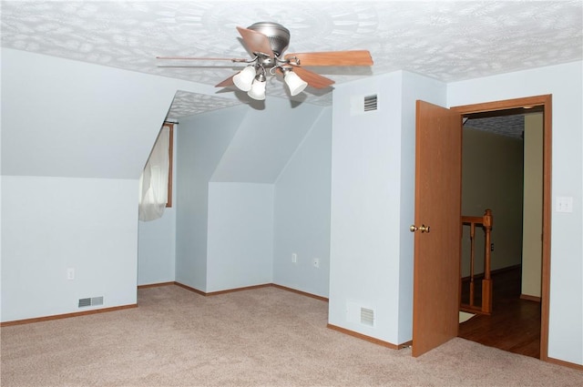 additional living space with carpet flooring, visible vents, baseboards, and a ceiling fan