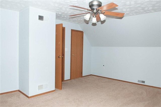 additional living space featuring light carpet, baseboards, visible vents, and ceiling fan