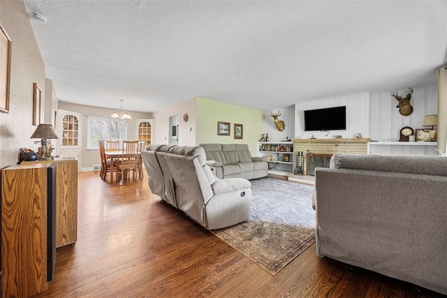 110 Thorncrest Dr, Penn Twp But, PA 16002 - living room with a brick fireplace, a chandelier, a textured ceiling, and dark wood-type flooring