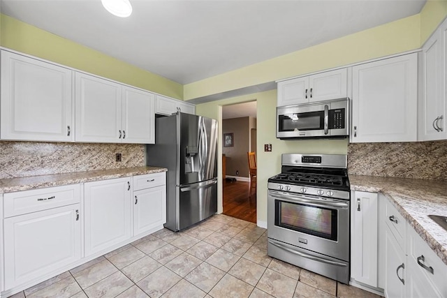 110 Thorncrest Dr, Penn Twp But, PA 16002 - kitchen with light stone countertops, white cabinets, appliances with stainless steel finishes, and decorative backsplash
