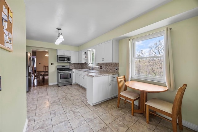 110 Thorncrest Dr, Penn Twp But, PA 16002 - kitchen featuring a sink, stainless steel appliances, pendant lighting, backsplash, and white cabinetry