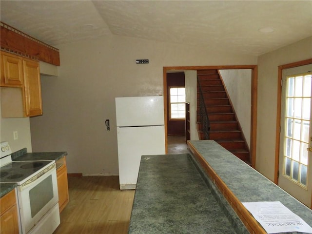 595 Amity Ridge Rd, Amwell, PA 15311 - kitchen featuring white appliances, light wood-style floors, dark countertops, lofted ceiling, and healthy amount of natural light