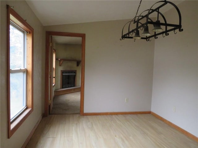 595 Amity Ridge Rd, Amwell, PA 15311 - unfurnished dining area with light wood-type flooring, a fireplace with raised hearth, and lofted ceiling