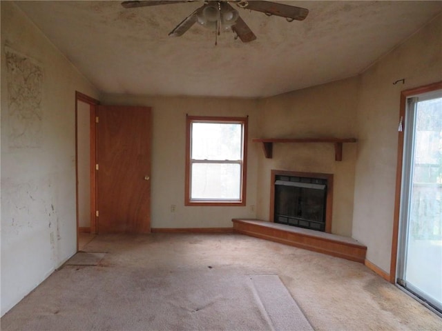 595 Amity Ridge Rd, Amwell, PA 15311 - unfurnished living room with carpet flooring, ceiling fan, a fireplace with raised hearth, and plenty of natural light