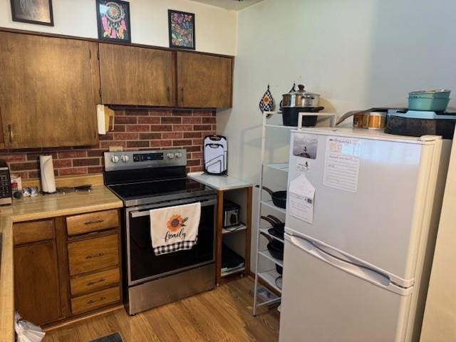 895 Donna Dr, Hermitage, PA 16148 - kitchen featuring freestanding refrigerator, brown cabinetry, light wood-type flooring, electric stove, and light countertops