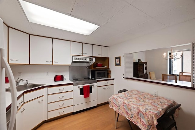 72 Linden Pl Unit 22, Sewickley, PA 15143 - kitchen with stainless steel microwave, a sink, an inviting chandelier, white electric range oven, and white cabinetry