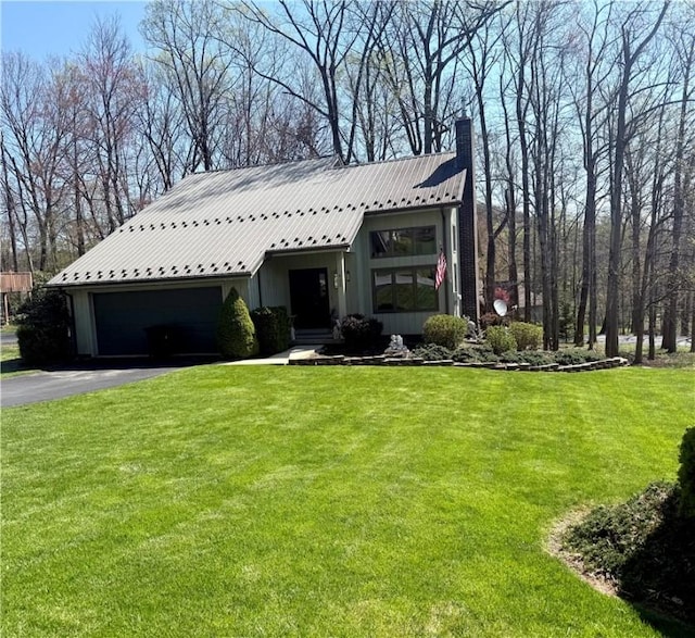 420 Edgewood Ave, White Twp Ind, PA 15701 - view of front of house with a garage, a chimney, metal roof, aphalt driveway, and a front yard