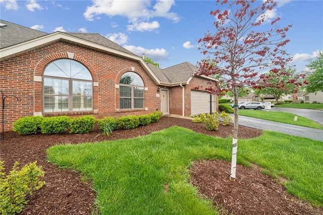 single story home featuring brick siding, a shingled roof, a garage, and driveway