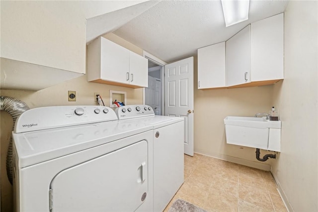laundry room featuring cabinet space, separate washer and dryer, baseboards, and light tile patterned floors