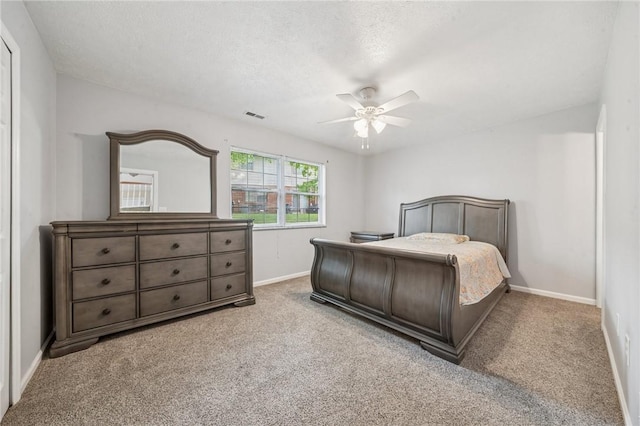 bedroom featuring carpet flooring, baseboards, ceiling fan, and a textured ceiling