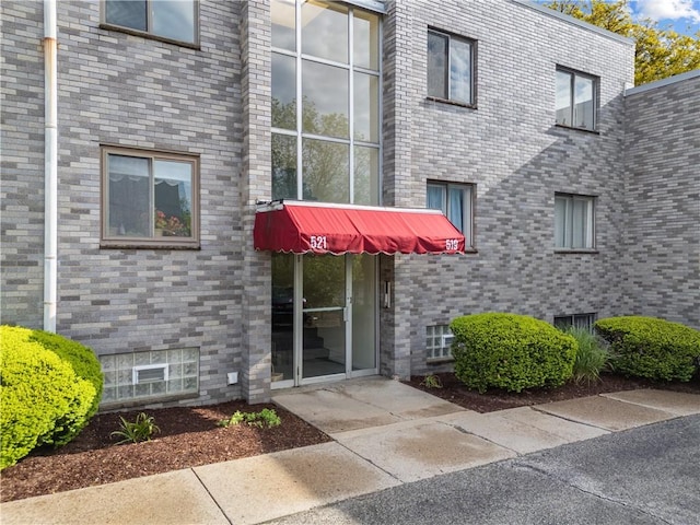 doorway to property featuring brick siding