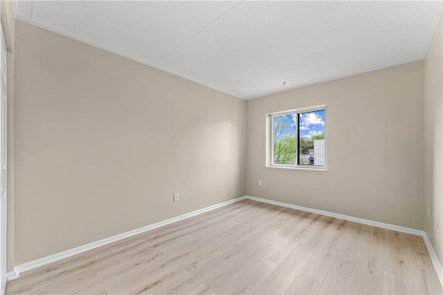 unfurnished room featuring baseboards and light wood-style floors