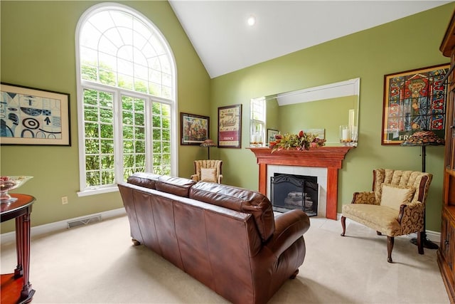 living area with light colored carpet, baseboards, and visible vents