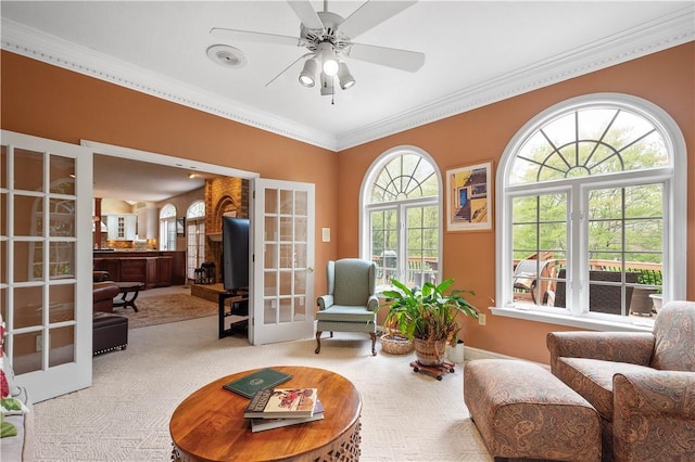 living area with crown molding, carpet floors, french doors, and a ceiling fan