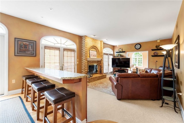 living room featuring baseboards and a fireplace