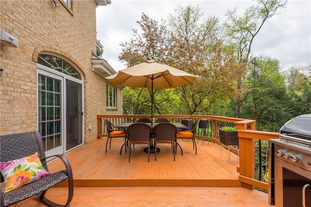 wooden terrace featuring outdoor dining area and grilling area