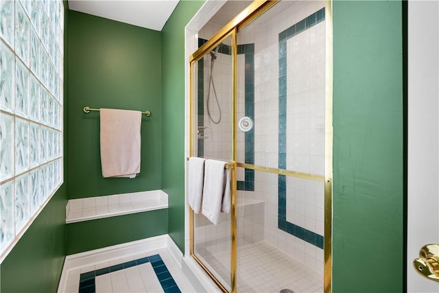 full bathroom with baseboards, tile patterned flooring, and a stall shower