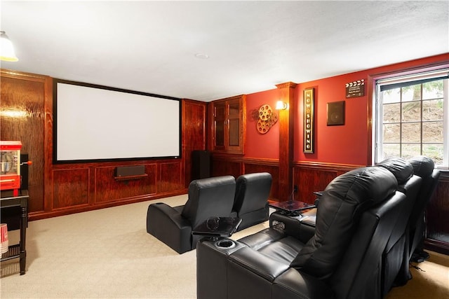 carpeted cinema room with a wainscoted wall