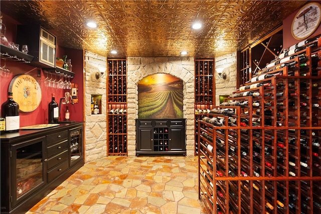 wine area with recessed lighting, beverage cooler, a dry bar, and an ornate ceiling