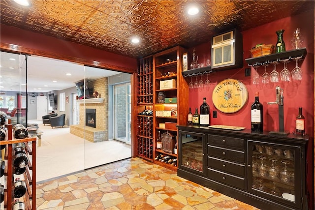 wine area with recessed lighting, a dry bar, a fireplace, and an ornate ceiling
