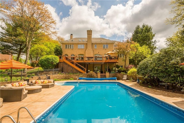 view of swimming pool featuring a fenced in pool, outdoor lounge area, stairs, a patio area, and a deck