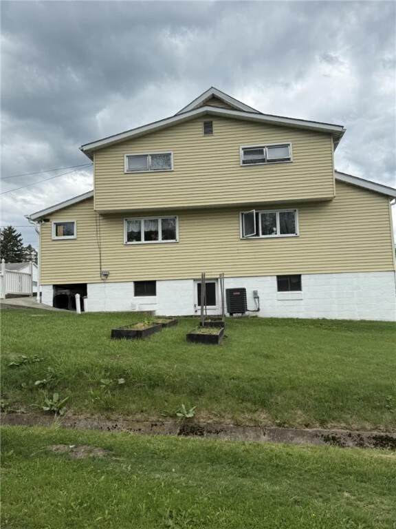 48 2nd St, Dunbar Twp, PA 15431 - rear view of property featuring central AC unit and a lawn
