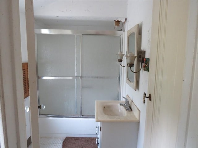 bathroom featuring enclosed tub / shower combo, tile patterned floors, and vanity