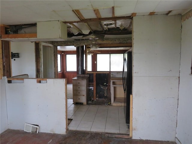 kitchen featuring freestanding refrigerator, light tile patterned flooring, and visible vents