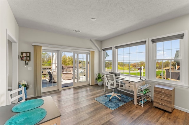 office space featuring a textured ceiling, visible vents, wood finished floors, and baseboards