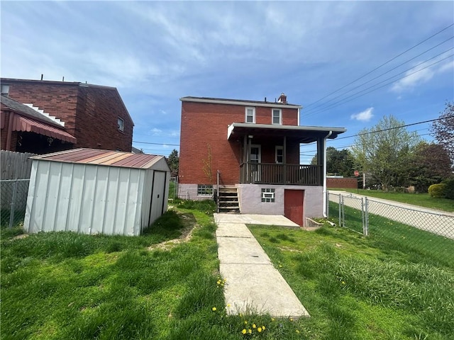 rear view of property with a storage shed, an outdoor structure, fence, and a lawn