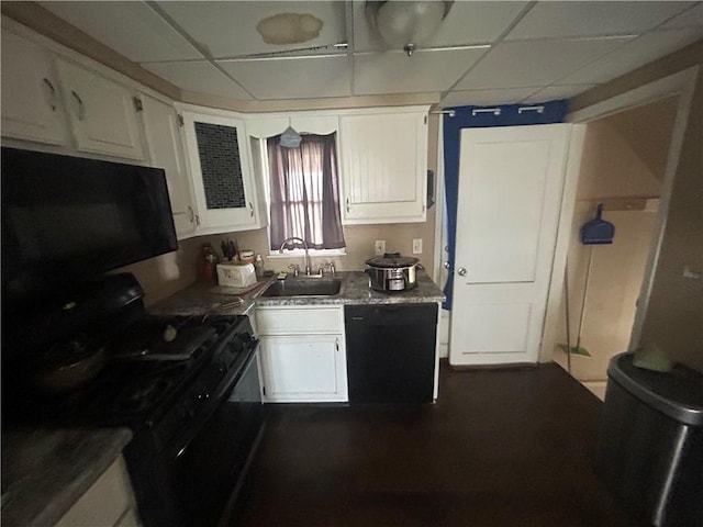 kitchen featuring a sink, white cabinetry, black appliances, and a paneled ceiling