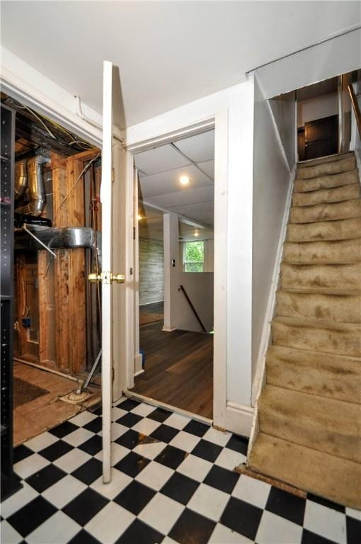 below grade area with tile patterned floors, recessed lighting, and stairs