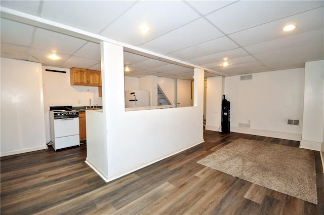 kitchen with white range, a drop ceiling, refrigerator, dark wood finished floors, and baseboards