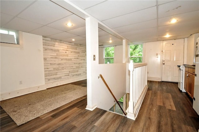 hall featuring an upstairs landing, dark wood finished floors, baseboards, and recessed lighting