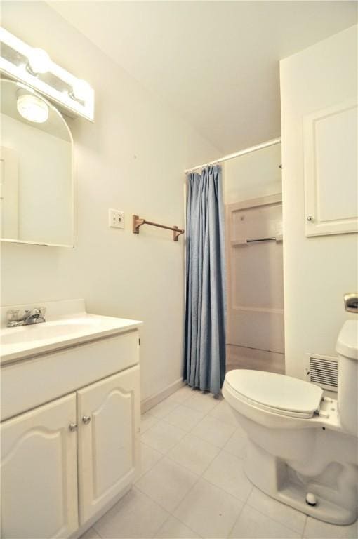 bathroom featuring toilet, vanity, a shower with curtain, and tile patterned floors