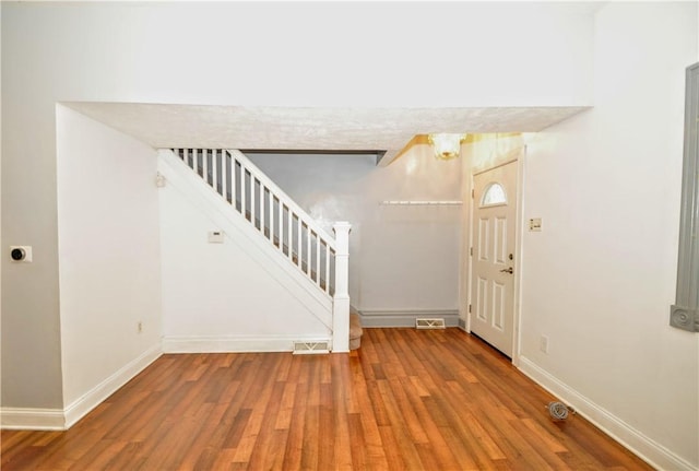 foyer entrance featuring stairway, wood finished floors, and baseboards