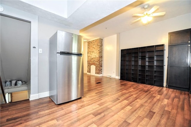 unfurnished living room featuring light wood-type flooring, baseboards, and a ceiling fan