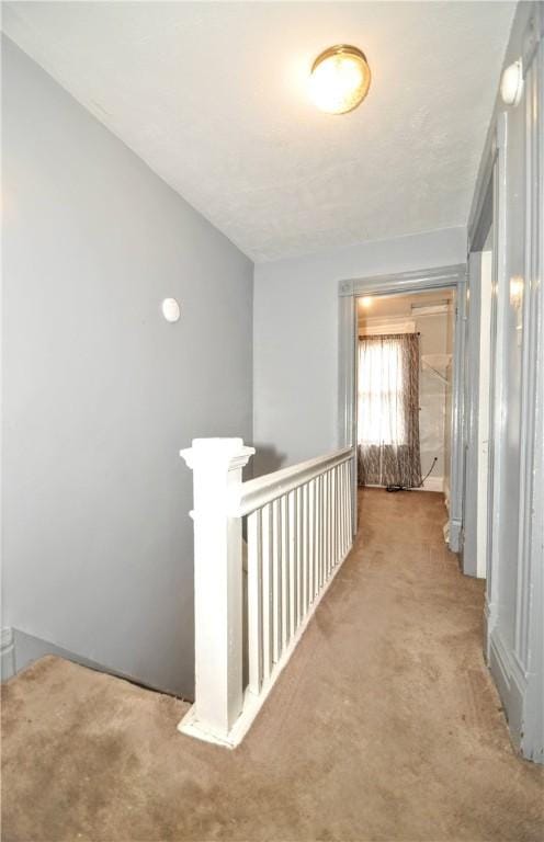 hallway with carpet and an upstairs landing